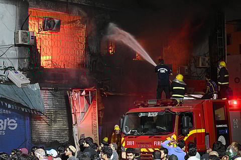 Firefighters douse a fire that broke out at a shopping mall in Karachi on January 18, 2026.