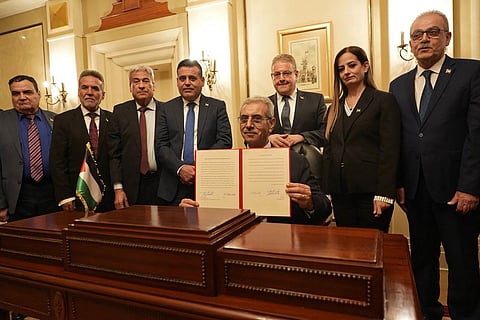 A handout photograph released by Egypt’s State Information Service shows Ali Shaath (centre), head of the new Palestinian technocratic committee for administering the Gaza Strip, posing with its members during the inaugural meeting of 'National Committee for the Administration of Gaza' (NCAG), in Cairo on January 18, 2026.