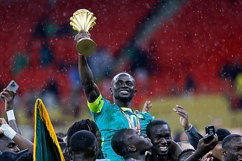 Senegal's forward #10 Sadio Mane holds up the trophy as he celebrates with his teammates after winning the Africa Cup of Nations (CAN) final football match against Morocco at the Prince Moulay Abdellah Stadium in Rabat on January 18, 2026.