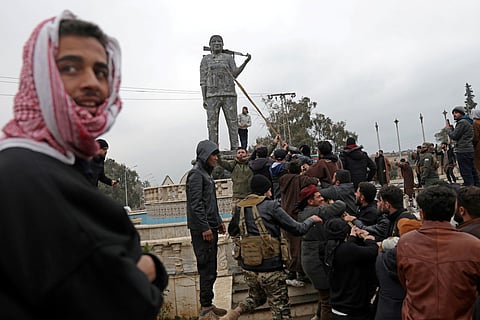 Residents bring down a statue of Habun Arab, who faught in the Women’s Protection Units, and who died in June 2017 fighting the Islamic State group militants, after the withdrawl of Kurdish-led forces in Tabqa, in Raqa province, on the southwestern banks of the Euphrates on January 18, 2026.
