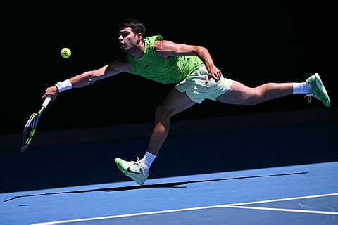Spain's Carlos Alcaraz hits a return against Germany's Yannick Hanfmann during their men's singles match on day four of the Australian Open tennis tournament in Melbourne on January 21, 2026.