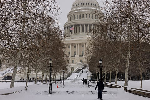 People walk in front of the US Capitol on January 25, 2026 in Washington, DC. A massive winter storm is expected to bring frigid temperatures, ice, and snow to millions of Americans across the nation.