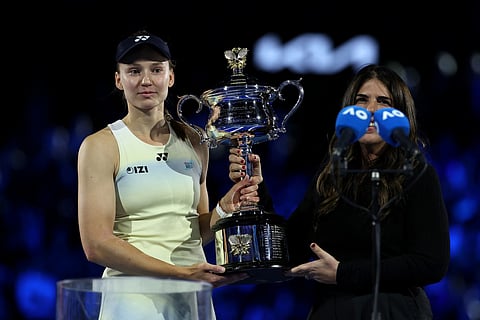 Kazakhstan's Elena Rybakina receives trophy after her victory against Belarus' Aryna Sabalenka in the women's singles final match on day fourteen of the Australian Open tennis tournament in Melbourne on January 31, 2026.