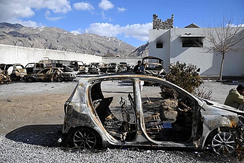 Burnt vehicles inside a torched police station on the outskirts of Quetta on February 1, 2026 a day after an attack by Baloch militants.