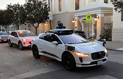 A Waymo driverless taxi stops on a street in San Francisco on Feb. 15, 2023.