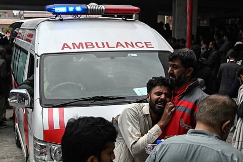 People mourn the death of their relatives following a suicide bombing at a mosque, outside a hospital in Islamabad.