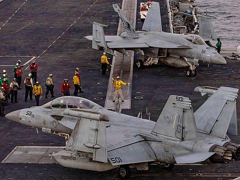 US sailors direct an EA-18G Growler, attached to Electronic Attack Squadron (VAQ) 133, on the flight deck of Nimitz-class aircraft carrier USS Abraham Lincoln in the Arabian Sea.
