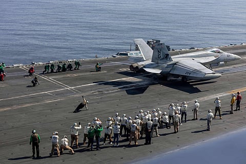 Observers, including US lead negotiators Steve Witkoff and Jared Kushner, watch flight operations on the flight deck of Nimitz-class aircraft carrier USS Abraham Lincoln (CVN 72) in the Arabian Sea, on February 7, 2026. US lead negotiators Steve Witkoff and Jared Kushner visited the USS Abraham Lincoln, signalling the persistent threat of US military action against Iran.