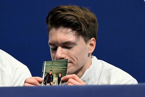 USA's Maxim Naumov holds a picture of his parents, who died in a plane crash last year, after competing in the figure skating men's singles short program during the Milano Cortina 2026 Winter Olympic Games at Milano Ice Skating Arena in Milan on February 10, 2026.