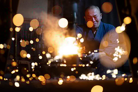 Sparks flying as swordsmith Akihira Kawasaki forges steel with a mechanical hammer at Kawasaki's workshop in Misato, Saitama prefecture.