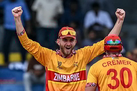 Zimbabwe's Brian Bennett (L) celebrates with teammate Graeme Cremer after their team's win in the 2026 ICC Men's T20 Cricket World Cup group stage match between Australia and Zimbabwe at the R Premadasa Stadium in Colombo on February 13, 2026.