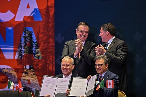 Canada's Minister of Internal Trade, Dominic LeBlanc (top-L) and Mexico's Secretary of Economy, Marcelo Ebrard (top-R), applaud after the signing of a memorandum of understanding during a meeting with Canadian business leaders in Mexico City on February 16, 2026.