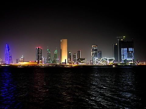 Taken on February 16, 2026, this picture shows the skyline of the Bahraini capital Manama at night.