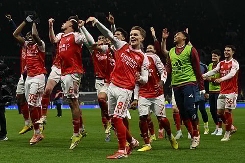 Arsenal celebrate their victory against Spurs with their travelling fans