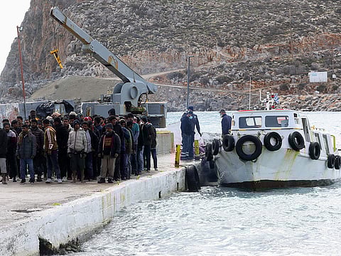 Migrants disembark from a boat at the port of Kali Limenes, in Heraklion, southern Crete.