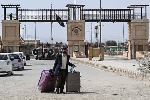 A Pakistani national walks across the Pakistan-Iran border after returning from Iran at Taftan, Balochistan. File photo