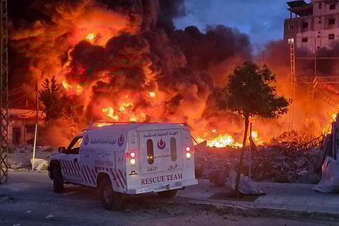An ambulance is parked near a sweeping blaze following Israeli bombardment on a solar farm and electricity generation facility in Lebanon's southern coastal city of Tyre on March 4, 2026.