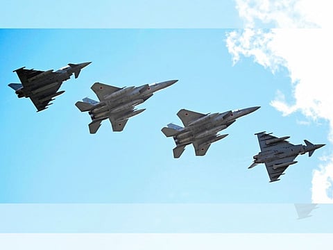 Eurofighter Typhoon (L and R) and Japanese Air Self-Defense Force F-15 fighter jets fly over the military air base in Laage, south of Rostock, northeastern Germany, during a demonstration as part of a press day on September 23, 2025.