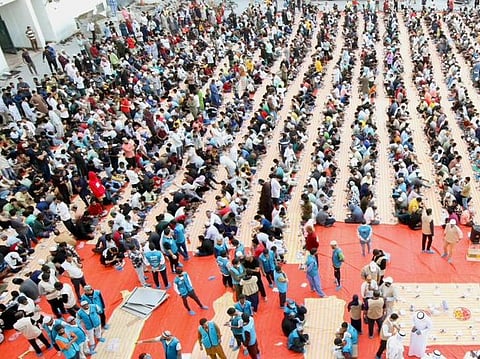 Volunteers with Model Service Society distribute iftar meals.