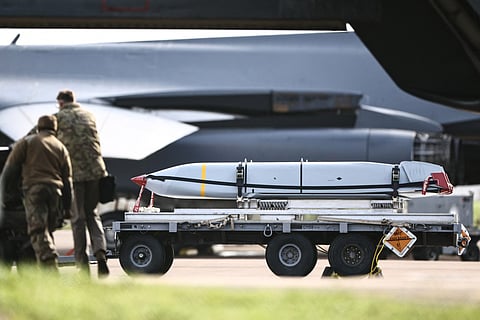 Military ground personnel are pictured next to cruise missiles which were unloaded from a US Air Force B-1 Lancer bomber on the tarmac at RAF Fairford in south-west England on March 11, 2026.