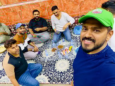 Rashid Abbas (extreme right) and Irshad Aboobacker (second from left) break their fast with fellow passengers during their 28-hour journey back to the UAE.
