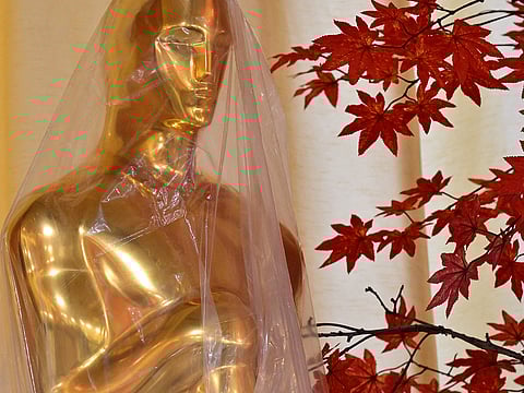 A decorative replica Oscar statue covered in protective plastic sheeting is seen as preparations are made on the red carpet arrivals area ahead of the 98th Annual Academy Awards in Hollywood, California, on March 13, 2026.