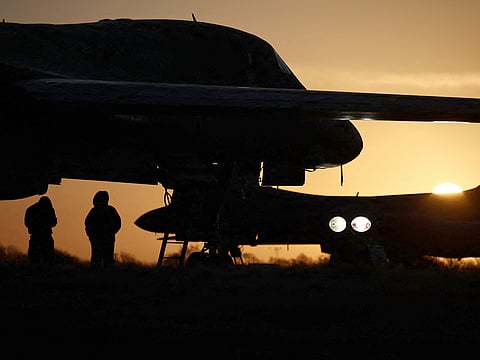 USAF military personnel work beneath a US Air Force (USAF) B-1 Lancer bomber jet takes at RAF Fairford in south-west England on March 14, 2026.
