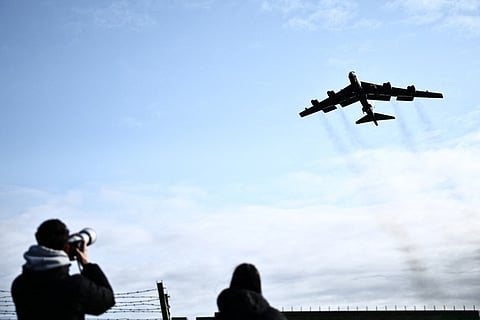 Plane spotters watch a US Air Force B-52 Stratofortress bomber taking off from RAF Fairford in south-west England on March 15, 2026.