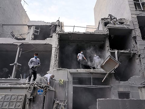 Volunteers clean debris from a residential building damaged when a nearby police station was hit in a US-Israeli strike in Tehran, Iran.