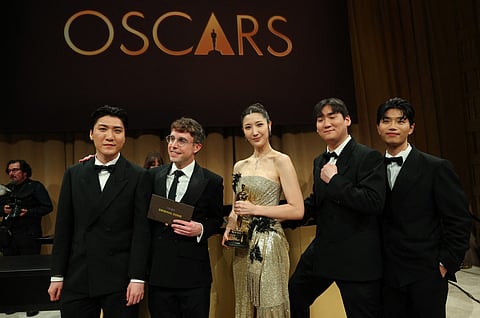 South Korean-US singer Ejae holds the Oscar for Best Music (Original Song) for "Golden" from "KPop Demon Hunters" with Jeong Hoon Seo (L), US songwriter Mark Sonnenblick (2L), Hee Dong Nam (2R) and Yu Han Lee (L) during the 98th Annual Academy Awards Governors Ball at the Dolby Theatre in Hollywood, California on March 15, 2026.