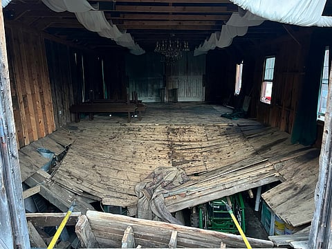 A photo provided by the New Hampshire State Fire Marshal's Office shows the buckled floor that collapsed Saturday, sending nearly 70 wedding guests into the basement of a building in Tamworth, N.H. Saturday, March 21, 2026. Six people were taken to the hospital with non-life-threatening injuries. (New Hampshire State Fire Marshal's Office via AP)