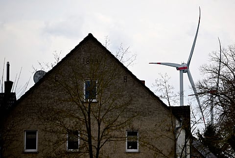 A windturbine of a windpark is seen near a house in Feldheim, eastern Germany on March 25, 2026.