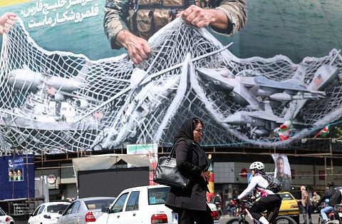An anti-US billboard depicting American aircraft being caught by Iranian armed forces in a fishing net beneath the words in Farsi, "The Strait of Hormuz will remain closed..." in Tehran.