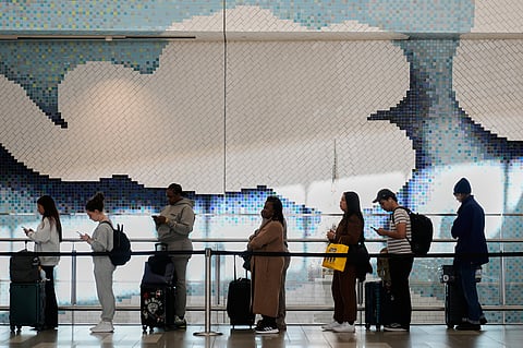 Travelers wait in a lines to get through security at LaGuardia Airport in New York, Monday, March 30, 2026.