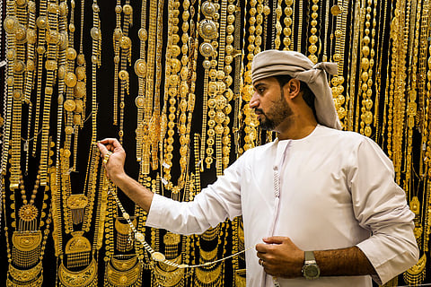 A gold dealer arranges a necklace in a jewellery shop at the Dubai Gold Souk earlier this week.
