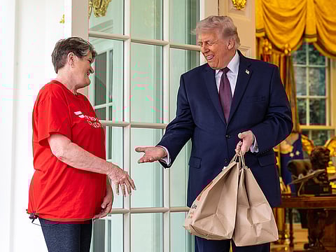 Sharon Simmons, with DoorDash, delivers McDonald's to President Donald Trump outside the Oval Office of the White House.