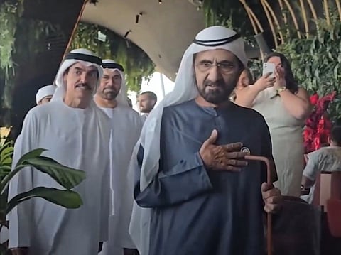 Guests cheer and film as Sheikh Mohammed interacts with diners.