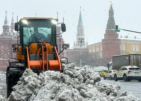 A communal worker operates a tractor to clear snow from a street in central Moscow during a snowstorm on April 27, 2026.