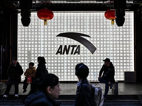 People walk past an Anta store in the Huangpu district of Shanghai
