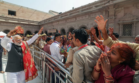Prime Minister Narendra Modi greets the devotees as he visits the Shri Kashi Vishwanath temple, in Varanasi on Wednesday.