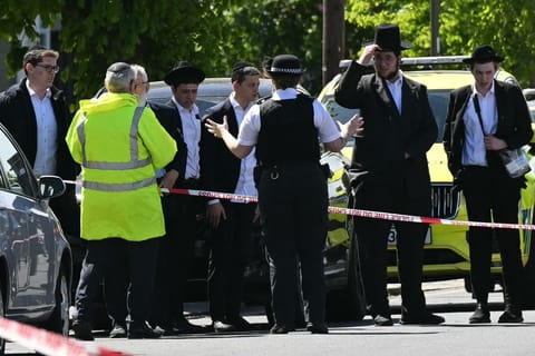 Local residents look on from outside a cordoned off area in the Golders Green neighbourhood of north London on April 29, 2026, following the stabbing to two people nearby.