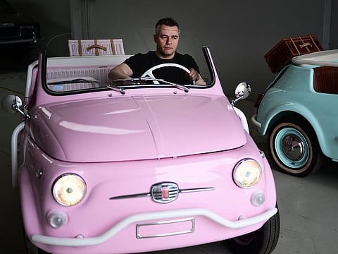 Owner of the Officine Gentile garage, Giovanni Gentile sits at the wheel of a model of a Fiat 500 Jolly Lido at his workshop in Turin.