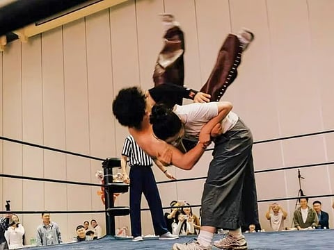 The blushing bride gets the better of her groom as she slams him onto the canvas.
