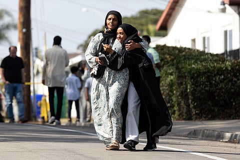 Two women cry as they leave a reunification center following the shooting at the Islamic Center of San Diego in southern California, on May 18, 2026.