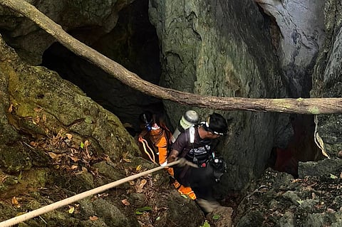 In this image released by Metta Tham Rescue Kalasin, rescuers try to reach people who have been trapped in a cave in Xaisomboun province, Laos, Tuesday, May 26, 2026.
