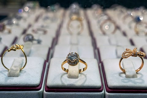 Diamond-encrusted gold rings are displayed in a storefront of a shop.
