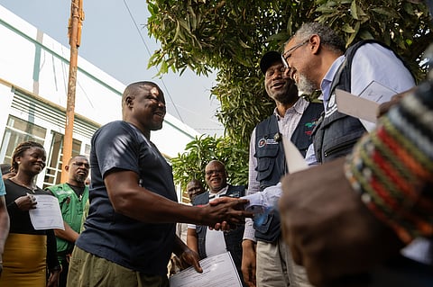 Director General of the World Health Organisation (WHO), Tedros Adhanom Ghebreyesus, right, shakes hands with Ezo Etienne, a health worker who recovered from Ebola in Bunia, Congo, Sunday, May 31, 2026. (AP Photo/Moses Sawasawa)