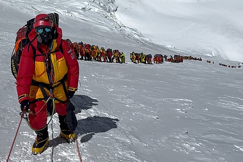This photograph taken on May 20, 2026, shows mountaineers climbing a slope lined up during their ascent to summit Mount Everest in Nepal.
