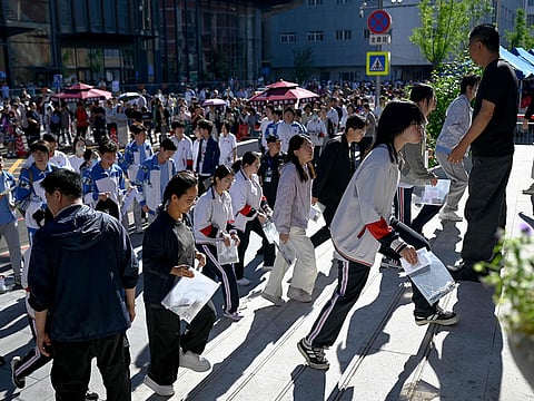 Students enter a school on the first day of China's National College Entrance Examination (NCEE) known as "gaokao", in Beijing.