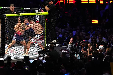 President Donald Trump (R, wearing white hat) watches the final fight of the night, a lightweight title bout between Ilia Topuria and Justin Gaethje at the UFC Freedom 250 fights taking place on the South Lawn of the White House on June 14, 2026 in Washington, DC. Trump was hosting a series of Ulitmate Fight Championship matches on his 80th birthday, which the White House is calling "a once-in-a-generation celebration of the American fighting spirit.”